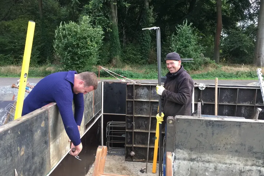 Mitglieder schalen das Fundament der Tribüne