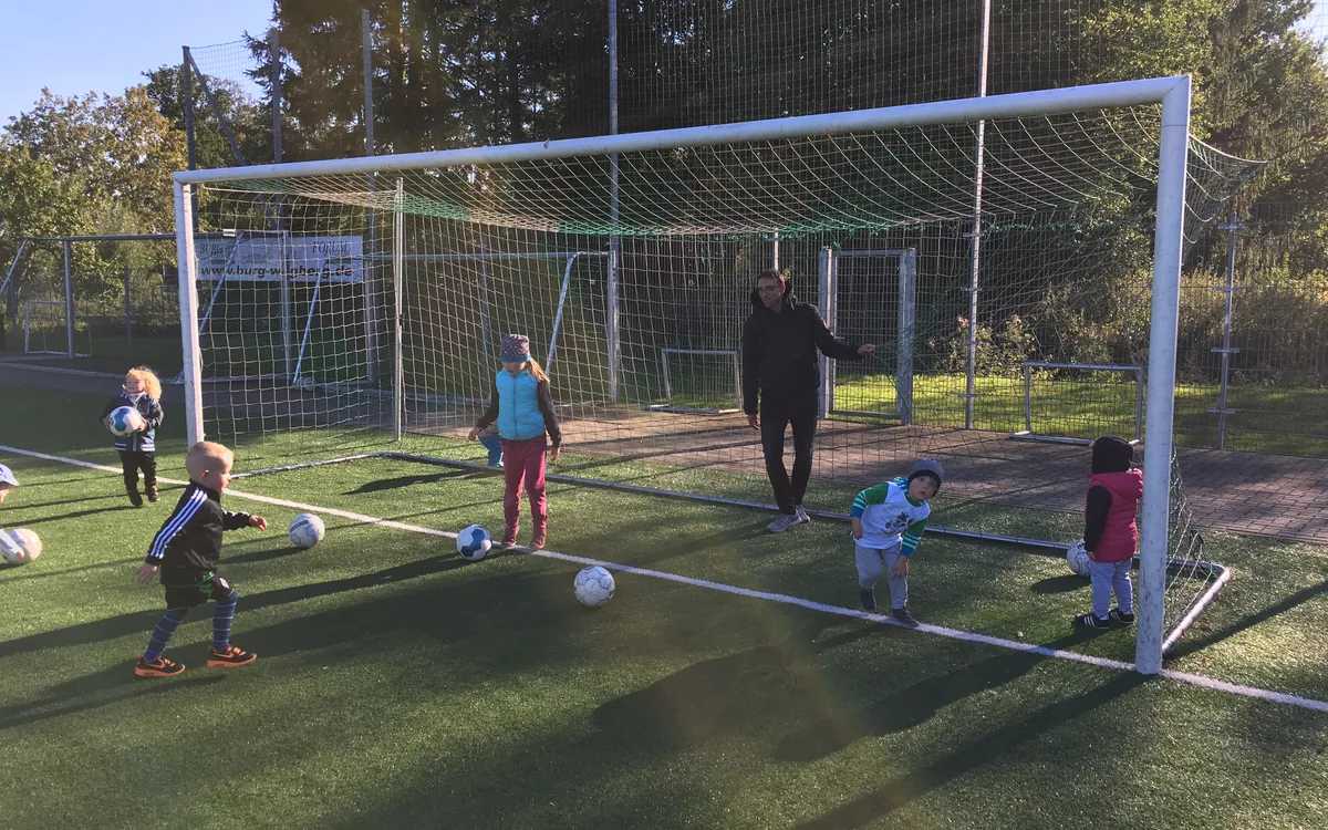 Children training in front of the goal on the artificial pitch