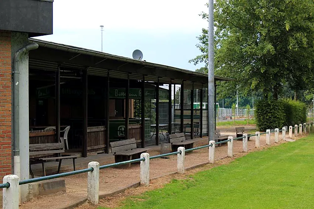 Terrace of the “En de Meer” clubhouse with benches by the grass pitch